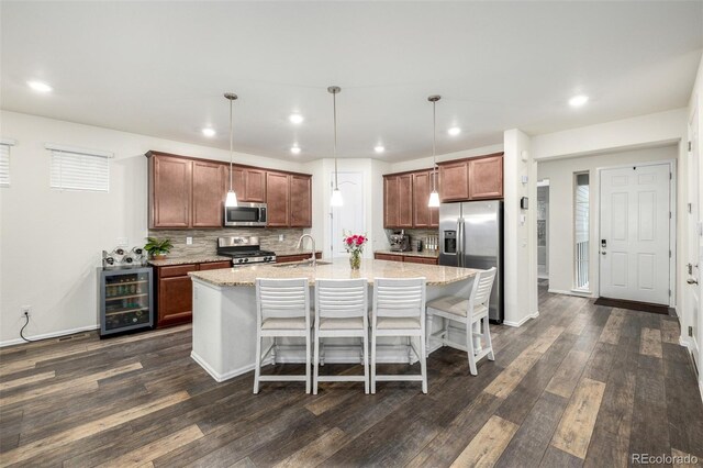 9723 Bennett Peak St, Littleton, CO 80125 - kitchen featuring appliances with stainless steel finishes, wine cooler, a sink, dark wood-style flooring, and recessed lighting