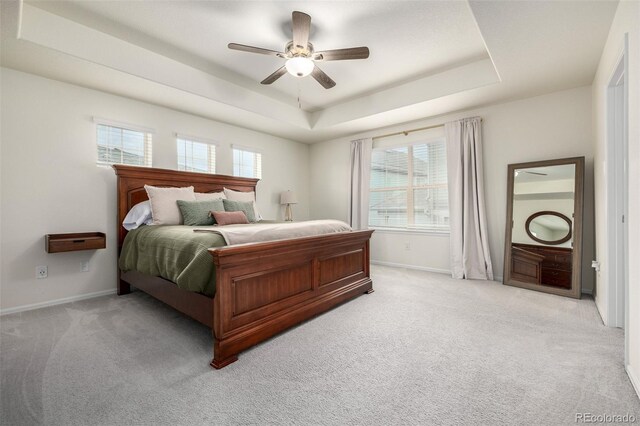 9723 Bennett Peak St, Littleton, CO 80125 - bedroom featuring a tray ceiling, light carpet, baseboards, and ceiling fan