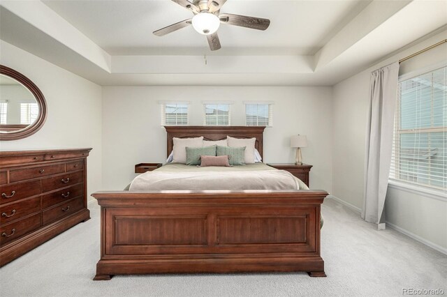 9723 Bennett Peak St, Littleton, CO 80125 - bedroom featuring light carpet, a tray ceiling, and multiple windows