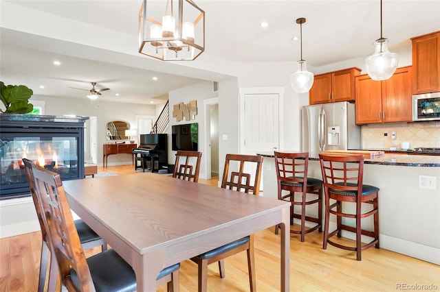 4414 Wolff St, Denver, CO 80212 - dining area featuring a multi sided fireplace, a ceiling fan, light wood-style floors, recessed lighting, and a chandelier