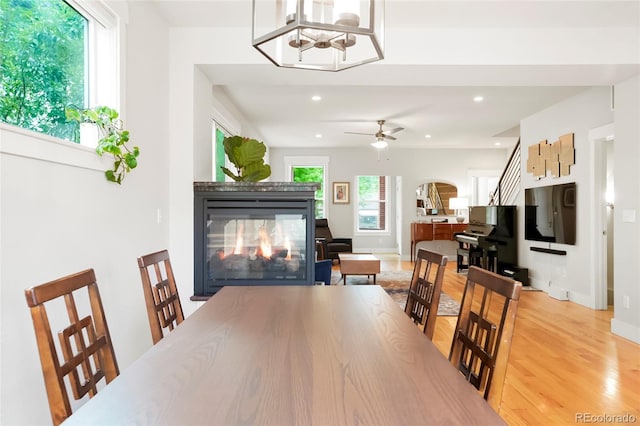 4414 Wolff St, Denver, CO 80212 - dining room with a multi sided fireplace, light wood-style flooring, recessed lighting, ceiling fan, and a chandelier