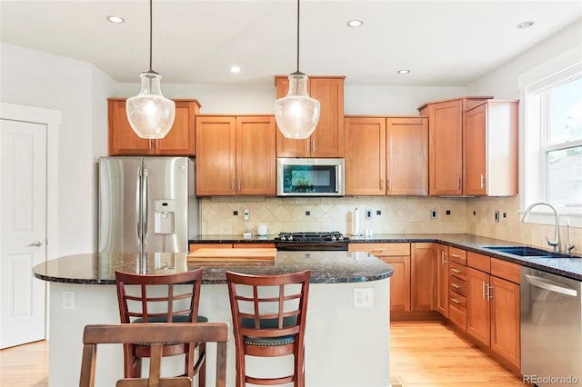 4414 Wolff St, Denver, CO 80212 - kitchen featuring appliances with stainless steel finishes, light wood finished floors, a kitchen island, pendant lighting, and recessed lighting
