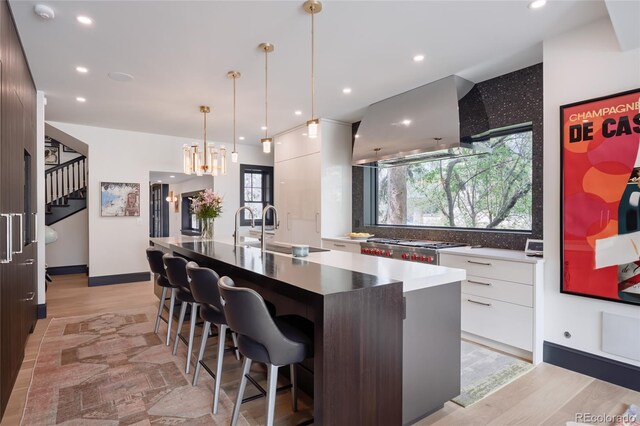 kitchen featuring ventilation hood, white cabinets, a sink, and modern cabinets