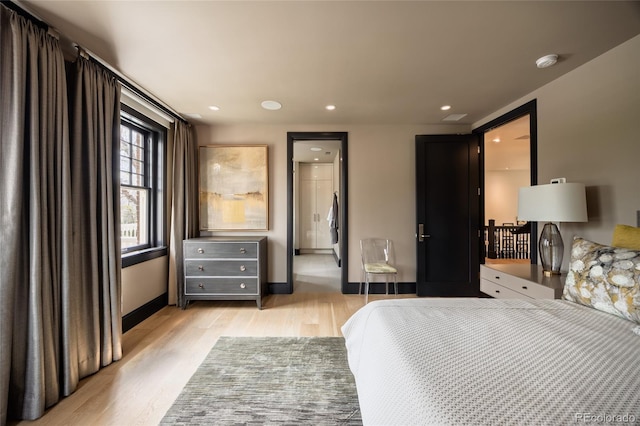 bedroom with baseboards, recessed lighting, and light wood finished floors