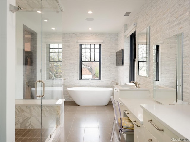 bathroom featuring vanity, tile patterned flooring, visible vents, a freestanding bath, and a stall shower