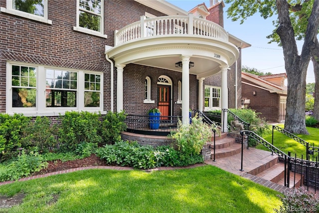 3309 E 7th Avenue Pkwy, Denver, CO 80206 - property entrance with a balcony, brick siding, a lawn, covered porch, and a chimney