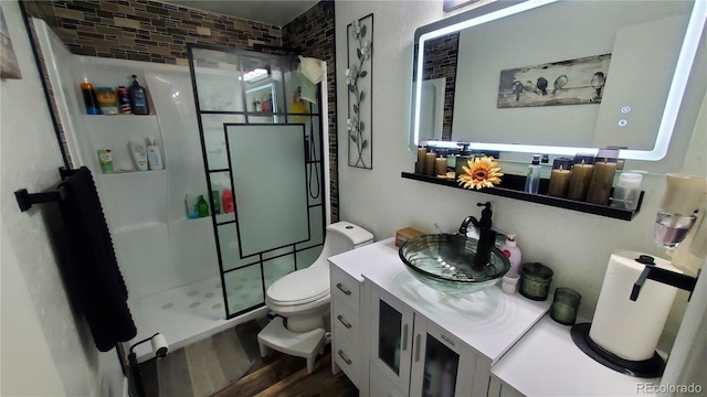 full bathroom featuring vanity, toilet, wood finished floors, and a stall shower