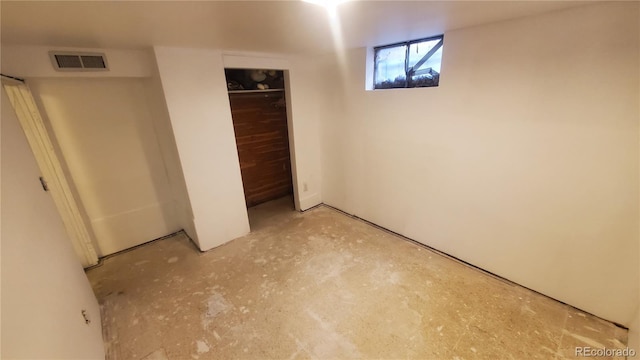 unfurnished bedroom with visible vents, unfinished concrete floors, and a closet