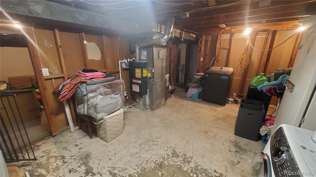 unfinished below grade area with heating unit and washer / dryer