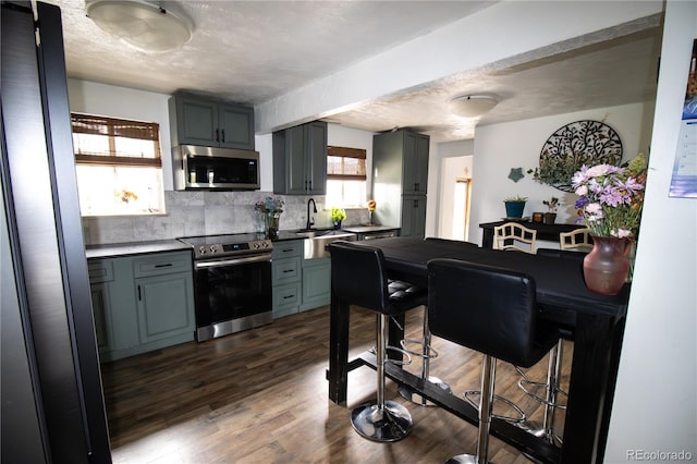 7620 Hooker St, Westminster, CO 80030 - kitchen with stainless steel appliances, gray cabinetry, a sink, and backsplash