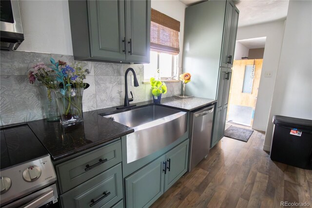 7620 Hooker St, Westminster, CO 80030 - kitchen with stainless steel dishwasher, a sink, backsplash, dark wood-style flooring, and dark stone counters