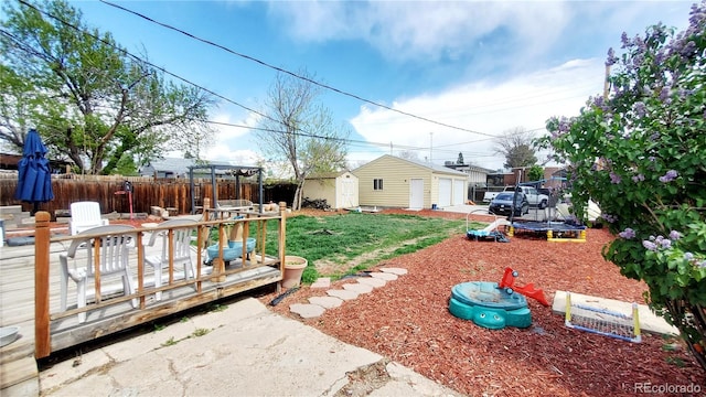 7620 Hooker St, Westminster, CO 80030 - view of yard featuring a trampoline, a wooden deck, and a detached garage