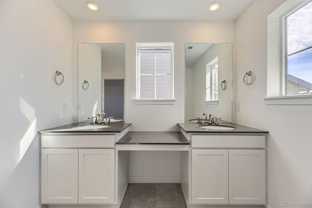 full bathroom featuring recessed lighting, two vanities, and a sink