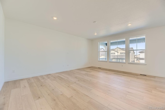 empty room with recessed lighting, baseboards, and light wood finished floors