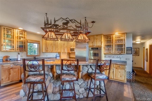 kitchen with a breakfast bar, a kitchen island, dark hardwood / wood-style flooring, and appliances with stainless steel finishes