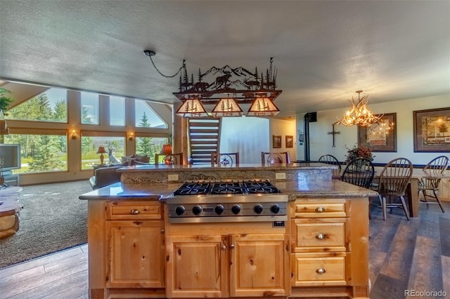 kitchen featuring dark hardwood / wood-style flooring, an inviting chandelier, a textured ceiling, and stainless steel gas cooktop