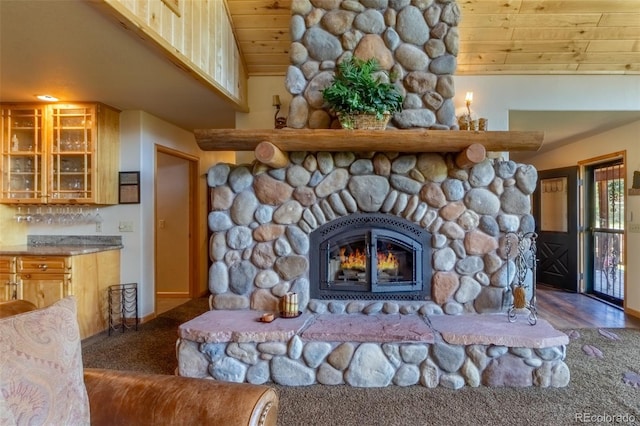 interior details with a stone fireplace, wood ceiling, and carpet floors