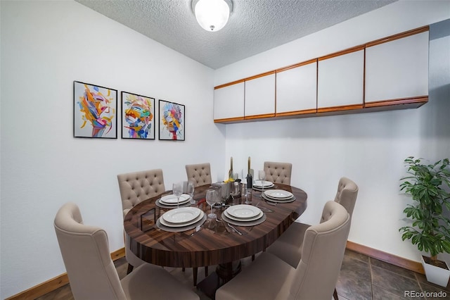 dining space with baseboards and a textured ceiling