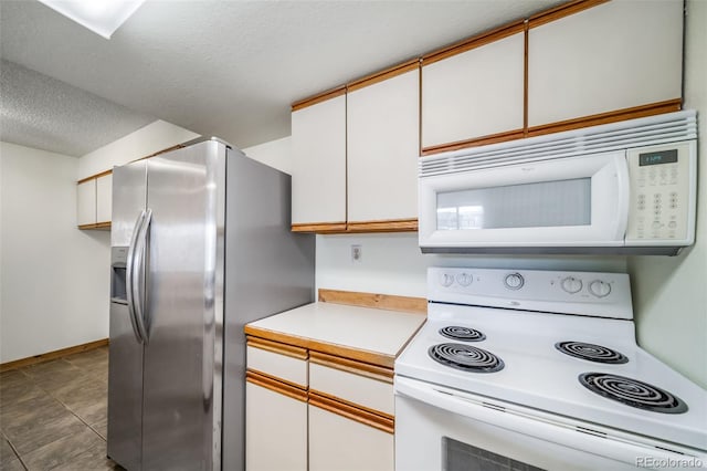 kitchen featuring white appliances, a textured ceiling, light countertops, white cabinets, and baseboards