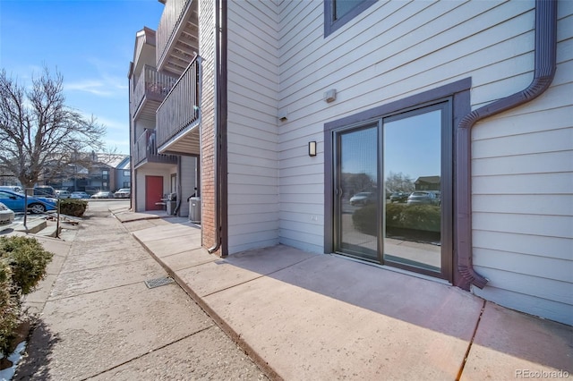 view of exterior entry with a balcony