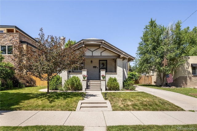 3743 N Yates St, Denver, CO 80212 - view of front of home featuring a front yard, a porch, and brick siding