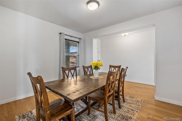 dining area featuring light wood-style flooring and baseboards