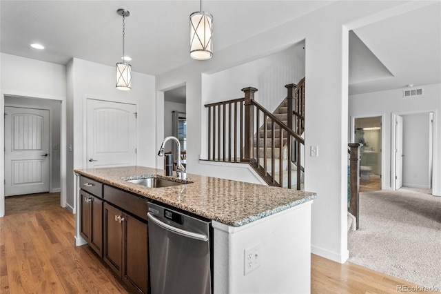 kitchen featuring light stone counters, pendant lighting, dark brown cabinetry, a sink, and dishwasher