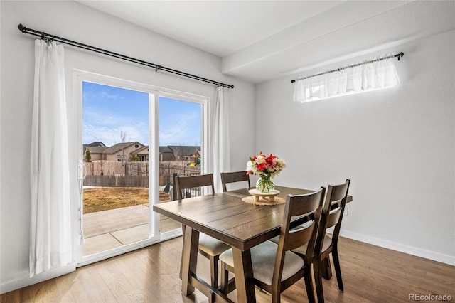 dining space with light wood-type flooring and baseboards