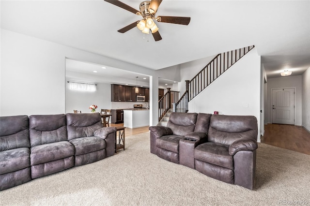 living area with light wood-style floors, stairway, a ceiling fan, and recessed lighting