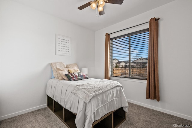 carpeted bedroom with ceiling fan and baseboards