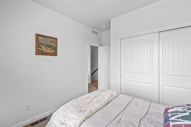 bedroom with a closet, visible vents, and baseboards