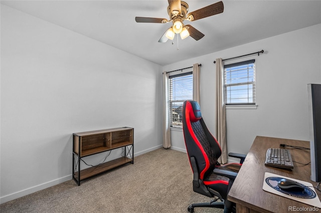 carpeted office space with baseboards and a ceiling fan