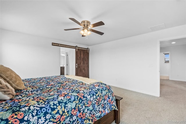 bedroom featuring carpet floors, visible vents, a barn door, ceiling fan, and baseboards