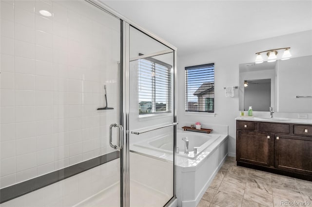 bathroom featuring a garden tub, a shower stall, ceiling fan, and vanity