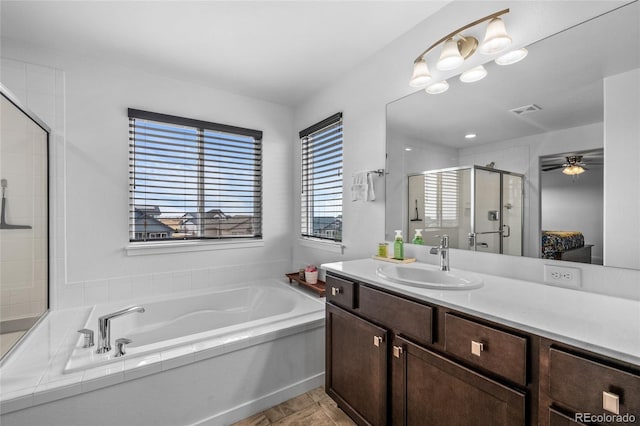 full bathroom featuring a stall shower, visible vents, a ceiling fan, a garden tub, and vanity