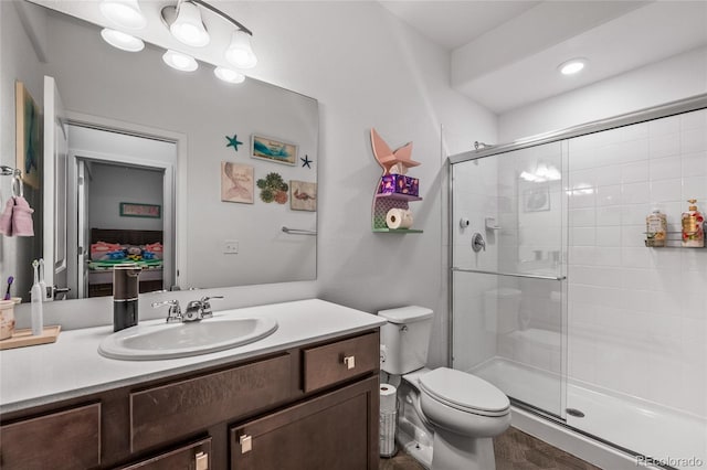 full bath with a stall shower, vanity, and toilet