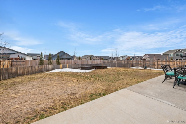 view of yard featuring a patio area, a fenced backyard, and a residential view