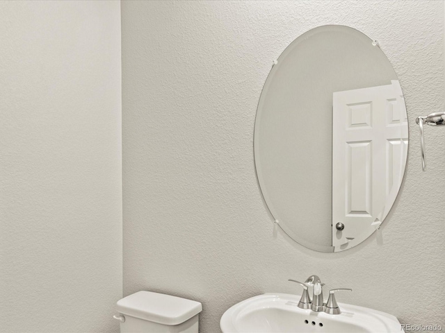 2728 73rd Avenue Ct, Greeley, CO 80634 - bathroom with a sink, toilet, and a textured wall