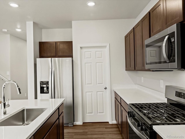 2728 73rd Avenue Ct, Greeley, CO 80634 - kitchen with appliances with stainless steel finishes, a sink, wood finished floors, dark brown cabinets, and light countertops