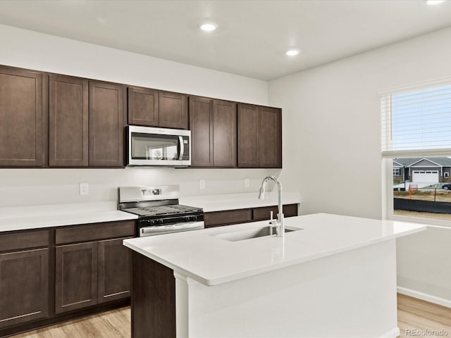 2728 73rd Avenue Ct, Greeley, CO 80634 - kitchen with stainless steel appliances, a sink, light wood-style flooring, dark brown cabinets, and recessed lighting