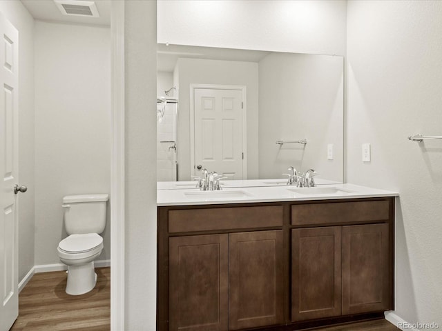 2728 73rd Avenue Ct, Greeley, CO 80634 - full bath with wood finished floors, toilet, double vanity, baseboards, and a shower