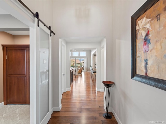 10553 Fairhurst Way, Highlands Ranch, CO 80126 - hallway featuring wood finished floors, baseboards, and a barn door