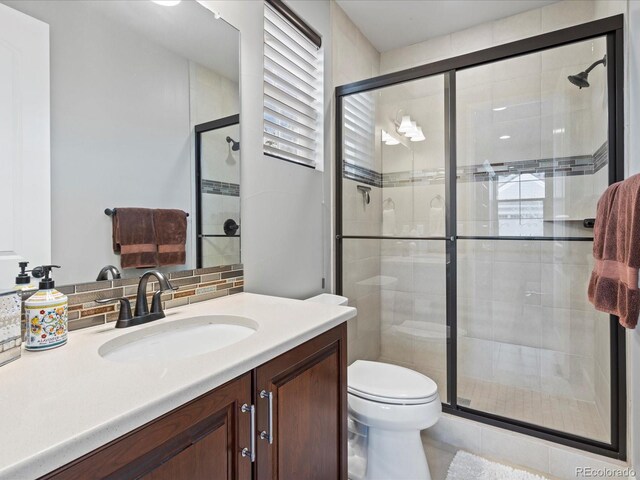 10553 Fairhurst Way, Highlands Ranch, CO 80126 - full bath with a shower stall, vanity, toilet, and backsplash