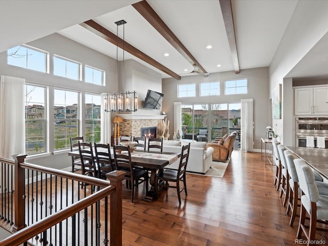 10553 Fairhurst Way, Highlands Ranch, CO 80126 - dining room featuring beamed ceiling, wood finished floors, a fireplace, healthy amount of natural light, and recessed lighting