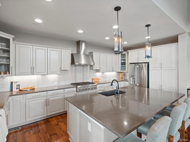 10553 Fairhurst Way, Highlands Ranch, CO 80126 - kitchen with a sink, wall chimney range hood, stainless steel appliances, dark wood-style floors, and white cabinets