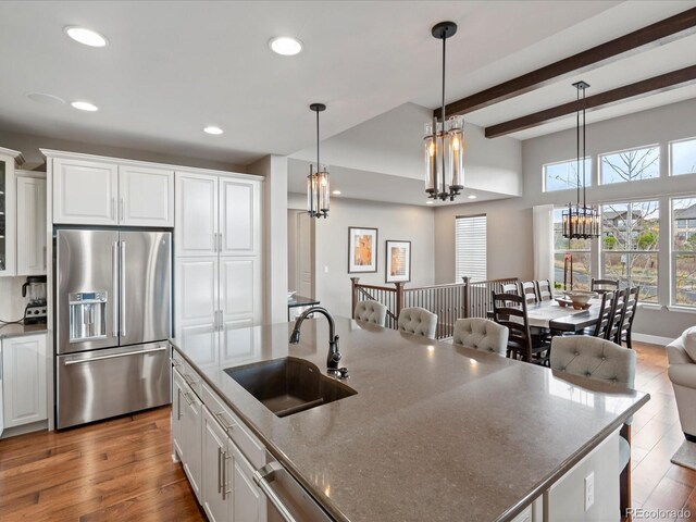 10553 Fairhurst Way, Highlands Ranch, CO 80126 - kitchen with appliances with stainless steel finishes, a sink, recessed lighting, white cabinetry, and decorative light fixtures