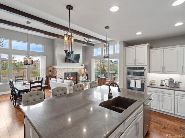 10553 Fairhurst Way, Highlands Ranch, CO 80126 - kitchen featuring a sink, appliances with stainless steel finishes, a tile fireplace, white cabinets, and recessed lighting