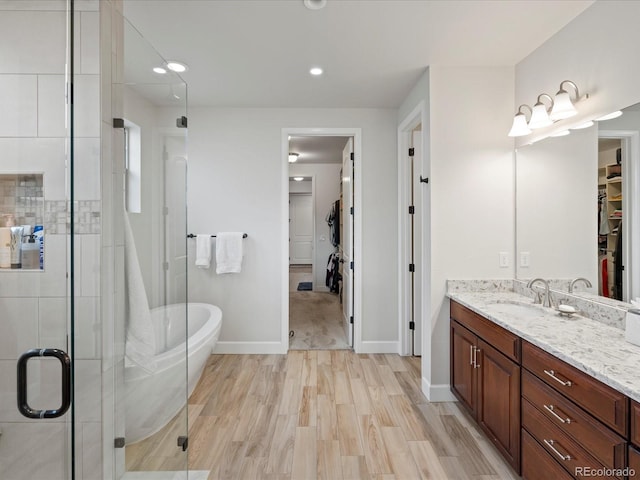 10553 Fairhurst Way, Highlands Ranch, CO 80126 - full bathroom with a stall shower, vanity, wood finished floors, baseboards, and recessed lighting