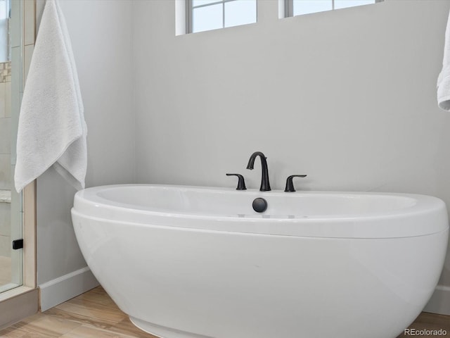 10553 Fairhurst Way, Highlands Ranch, CO 80126 - full bath featuring baseboards, a freestanding bath, wood finished floors, and a shower stall