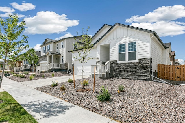 13322 E 110th Way, Commerce City, CO 80022 - craftsman inspired home featuring stone siding, a residential view, concrete driveway, board and batten siding, and an attached garage